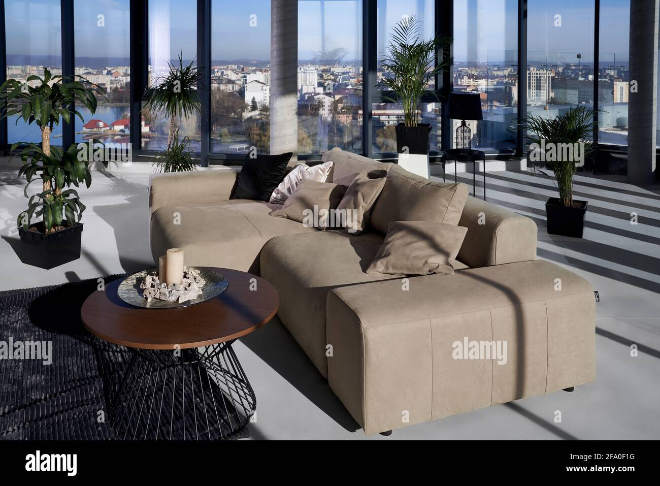 Gros plan sur un canapé en cuir beige tendance et une grande fenêtre  panoramique avec une vue incroyable sur la ville. Concept de maison moderne  avec beau intérieur et fenêtre élégante Photo