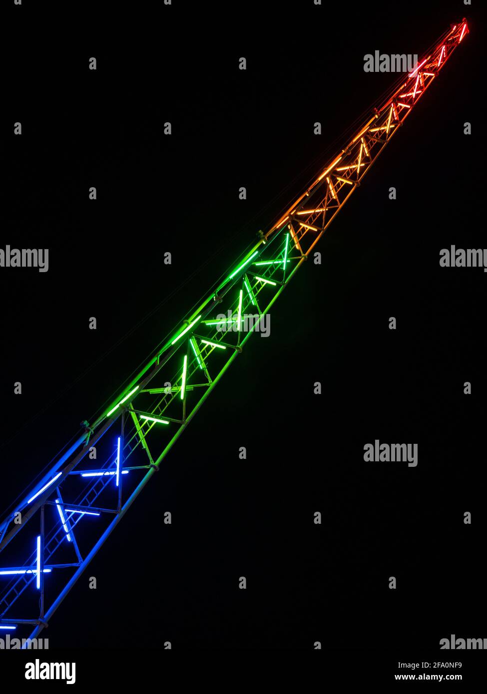 La catapulte de High Slingshot fait une tour en acier mise en valeur par des lumières LED colorées dans un parc d'attractions Luna sur le fond d'un ciel noir à Ayia Napa. Banque D'Images