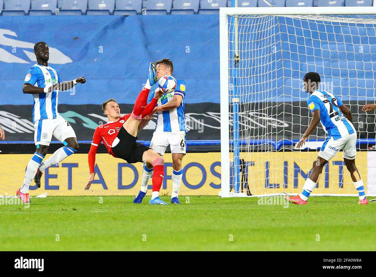 John Smith's Stadium, Huddersfield, Angleterre - 21 avril 2021 Jonathan Hogg (6) de Huddersfield est courageux comme Cauley Woodrow (9) de Barnsley tente un coup de pied pendant le match Huddersfield v Barnsley, Sky Bet EFL Championship 2020/21, John Smith's Stadium, Huddersfield, Angleterre 21 avril 2021 crédit : Arthur Haigh/WhiteRosephotos/Alamy Live News Banque D'Images
