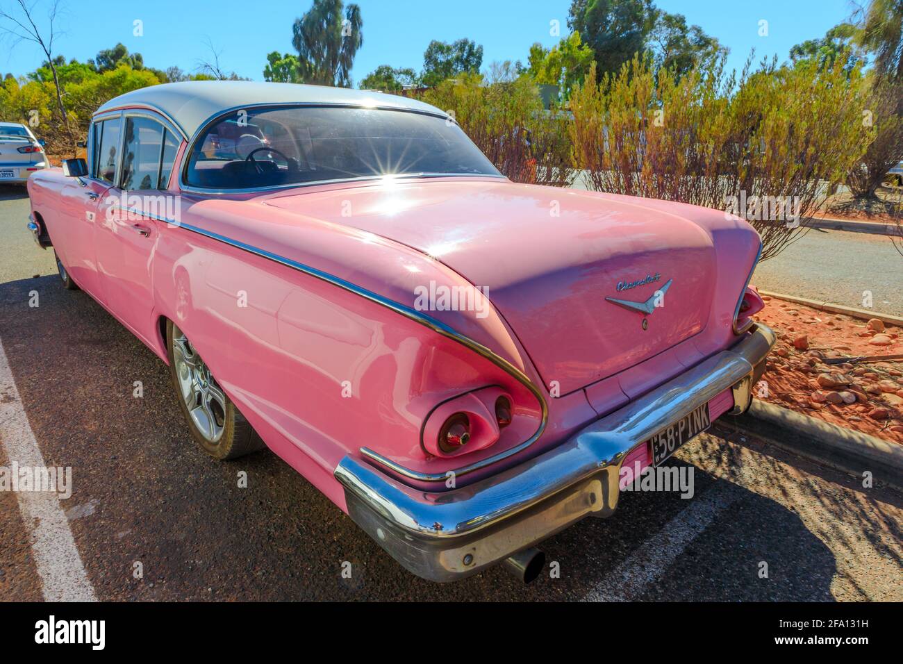 Yulara, territoire du Nord, Australie - 24 août 2019 : vue arrière d'une luxueuse voiture rose vintage de Chevrolet Bel Air III, à proximité d'Uluru-Kata Tjuta Banque D'Images