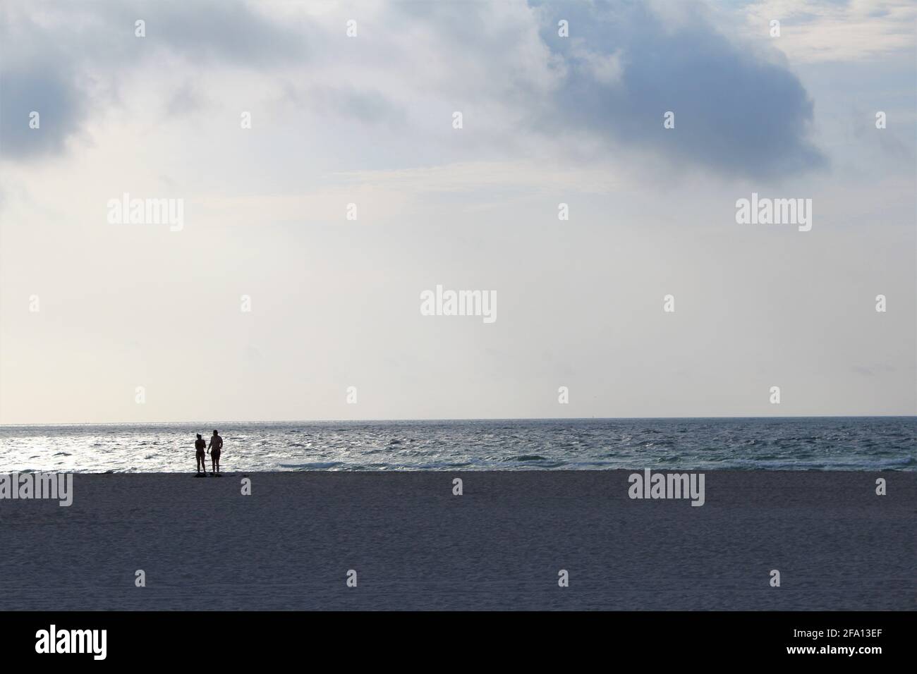 Lever du soleil à South Beach dans la ville de Miami Beach en Floride avec un couple marchant le long de la rive. Silhouette de couple. L'amour et le concept romantique Banque D'Images