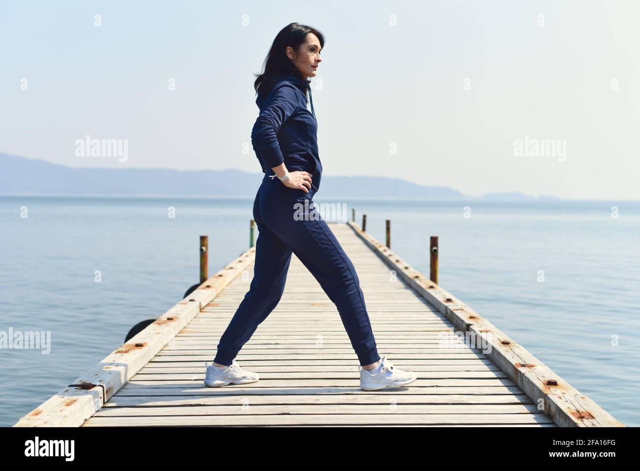 45 ans Femme russe qui s'accroupisse sur une jetée en bois au bord de la mer japonaise Banque D'Images