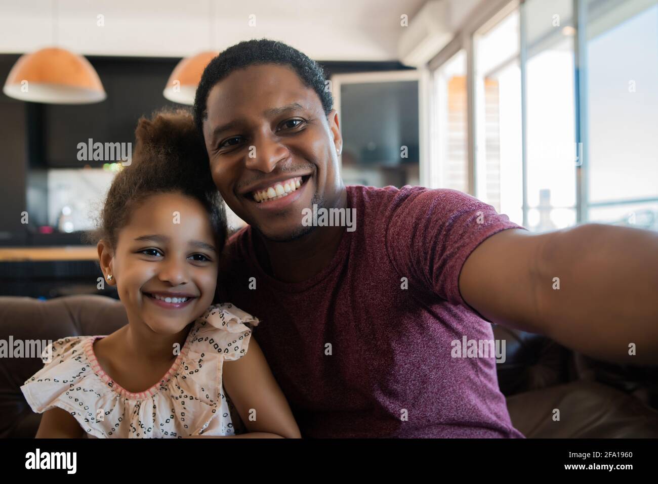 Fille et père prenant un selfie à la maison. Banque D'Images
