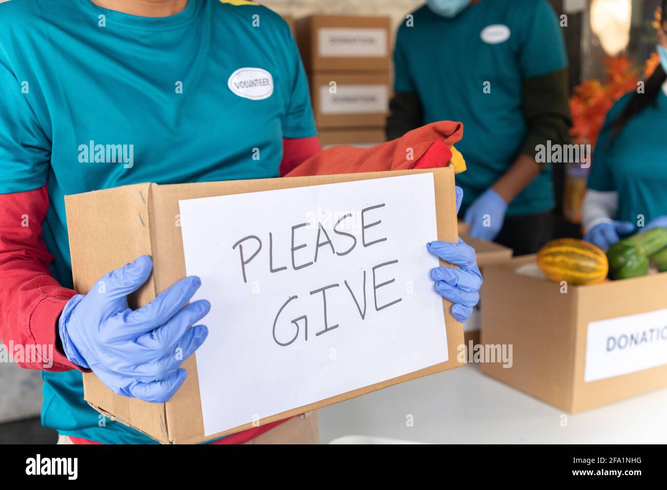 Porte-dons de bénévoles avec message d'affichage : concept de demande de services sociaux, œuvres caritatives pendant le coronavirus Banque D'Images