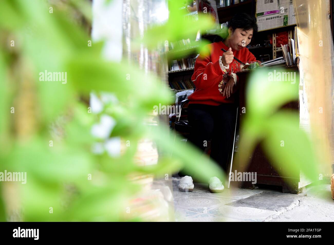 (210422) -- HEFEI, 22 avril 2021 (Xinhua) -- Chen Guixia a déjeuné à la librairie Zengzhi à Hefei, dans la province d'Anhui, en Chine orientale, le 20 avril 2021. Depuis son ouverture il y a 21 ans, Zengzhi Bookshop, un marchand de livres non-descript de seconde main dans le centre-ville d'Hefei, a été salué comme un monument intellectuel parmi les fans de livres locaux. Son ancien propriétaire, Zhu Chuanguo, s'est vanté d'une collection de 20,000 livres d'occasion, tous achetés auprès de lecteurs ordinaires et de points de recyclage.selon la vision de Zhu, les livres coulés peuvent s'avérer instructifs pour quelqu'un d'autre qui mérite donc un lecteur ami Banque D'Images
