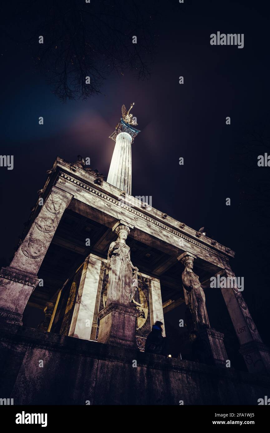 Le Friedensengel à Munich la nuit. Un monument avec un ange doré sur le dessus, des pierres de mosaïque et quelques statues. Construit pendant l'époque Barock. Banque D'Images