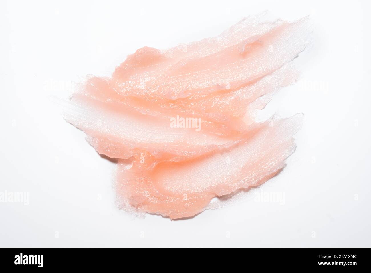 Échantillon de produit cosmétique texture de gel crémeuse taches sur fond blanc. Gommage cosmétique rose texturé pour le visage et le corps - image Banque D'Images