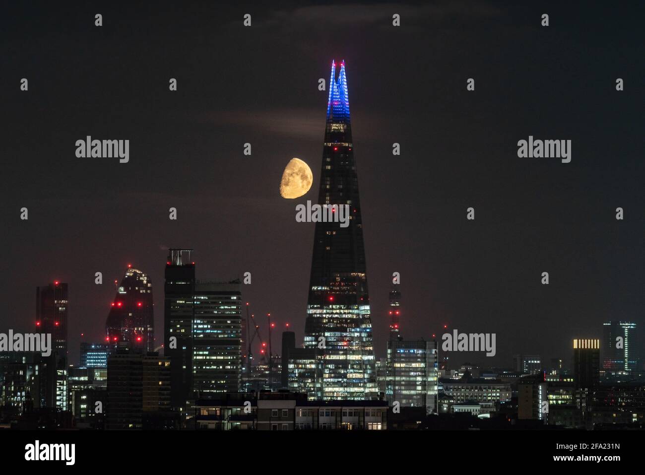 Londres, Royaume-Uni. 22 avril 2021. Météo au Royaume-Uni : une lune de Gibbous à 75 % de cire continue de se coucher tôt jeudi derrière le gratte-ciel de Shard, suivant une direction nord-ouest. Credit: Guy Corbishley/Alamy Live News Banque D'Images