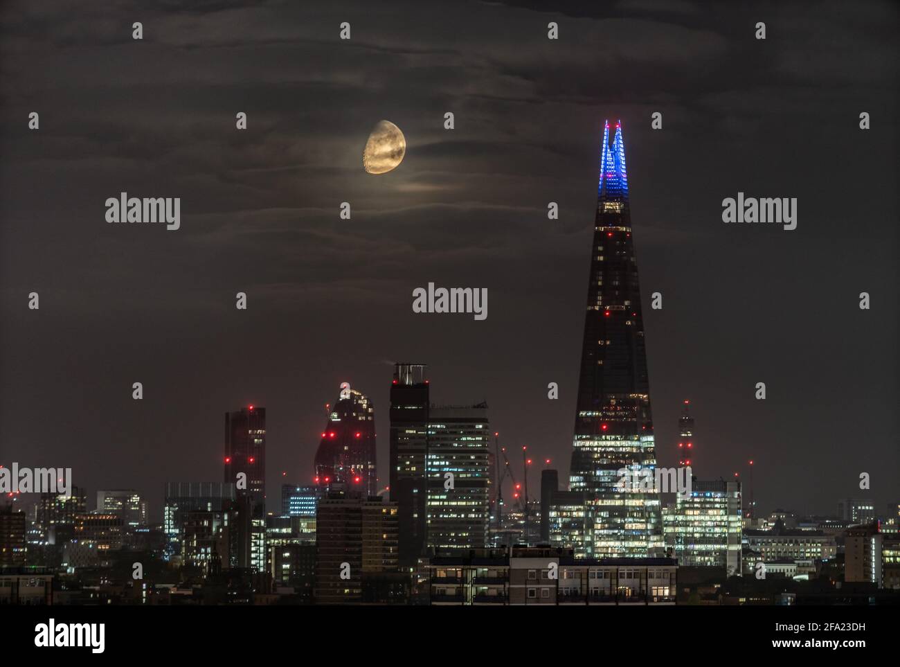 Londres, Royaume-Uni. 22 avril 2021. Météo au Royaume-Uni : une lune de Gibbous à 75 % de cire continue de se coucher tôt jeudi derrière le gratte-ciel de Shard, suivant une direction nord-ouest. Credit: Guy Corbishley/Alamy Live News Banque D'Images