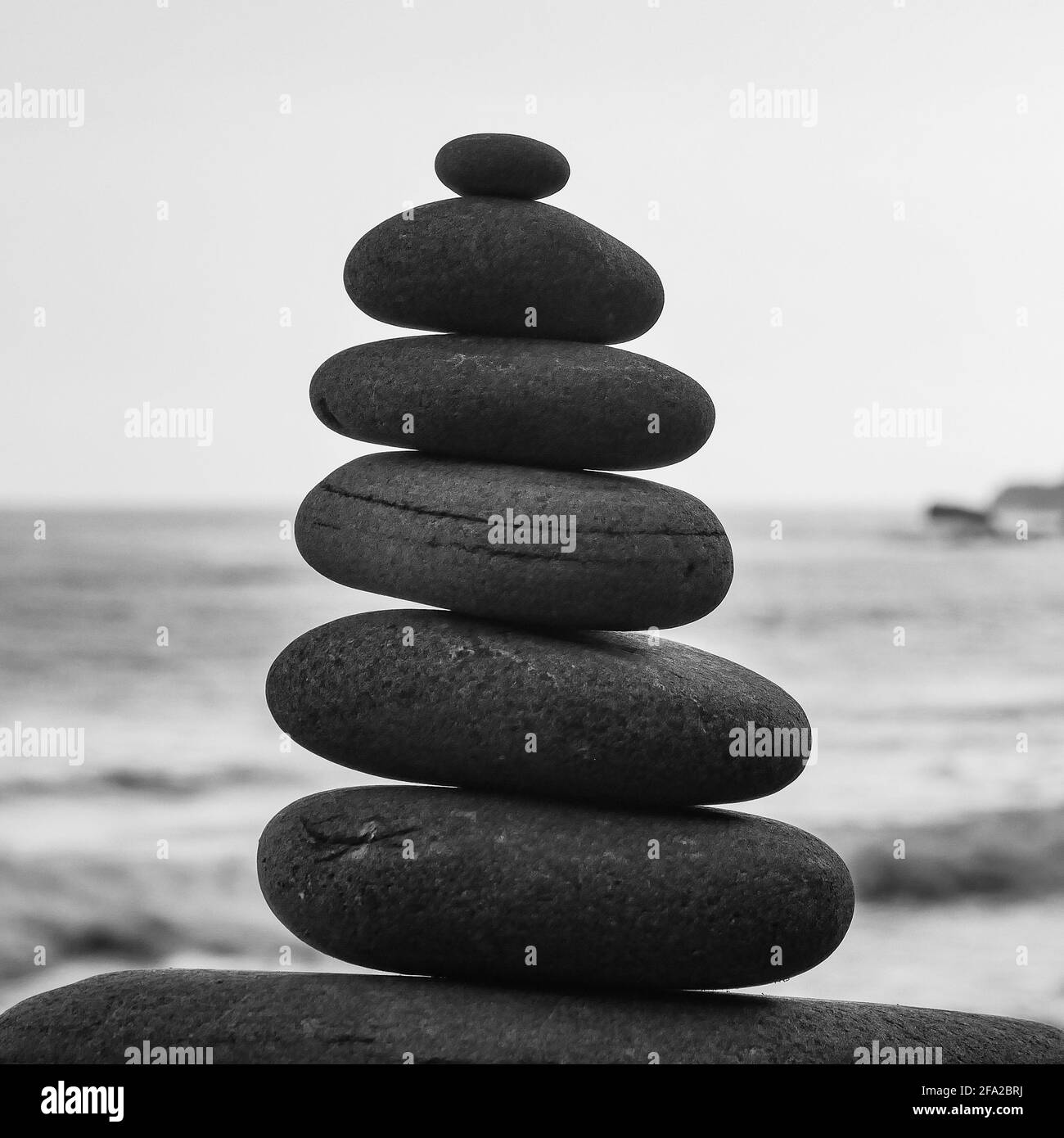 Piles de pierre faites le long d'une plage et de la mer dedans l'arrière-plan Banque D'Images