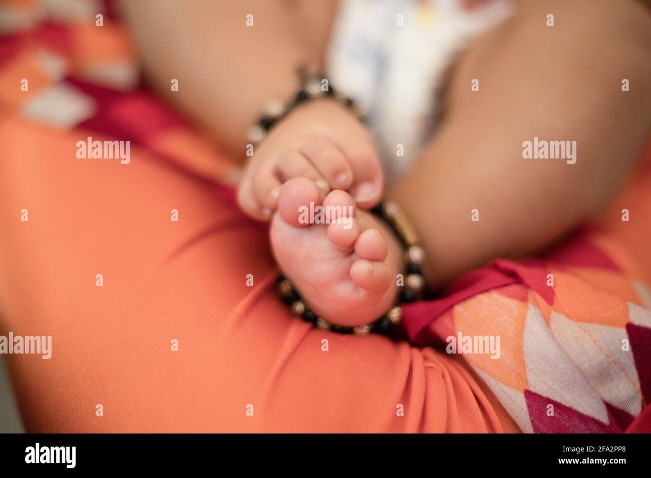Gros plan de jolis pieds de bébé indien avec bracelets Banque D'Images