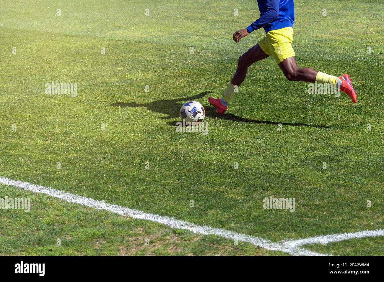 Un joueur de football se prépare à lancer le ballon sur un terrain d'herbe naturelle. Banque D'Images