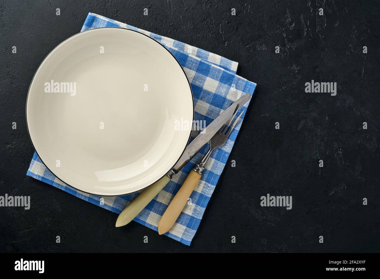 Table de cuisine avec plaque vide de couleur blanche, nappe bleue et espace pour votre recette ou votre menu. Vue de dessus. Maquette. Banque D'Images