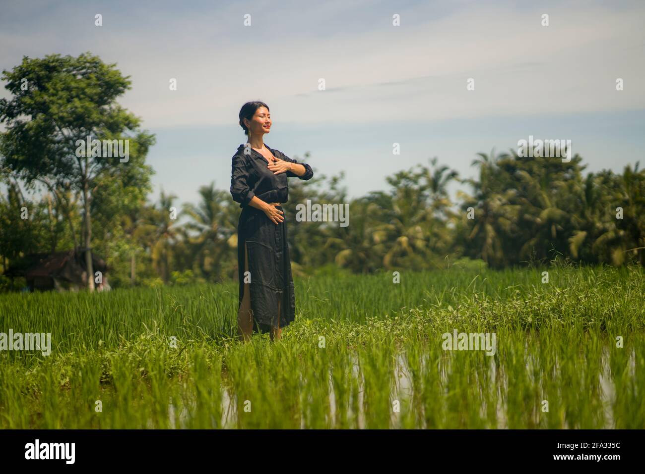 Portrait artistique de jeune femme asiatique attrayante et heureuse en plein air au champ de riz vert, danse et méditation spirituelle sur beau Banque D'Images