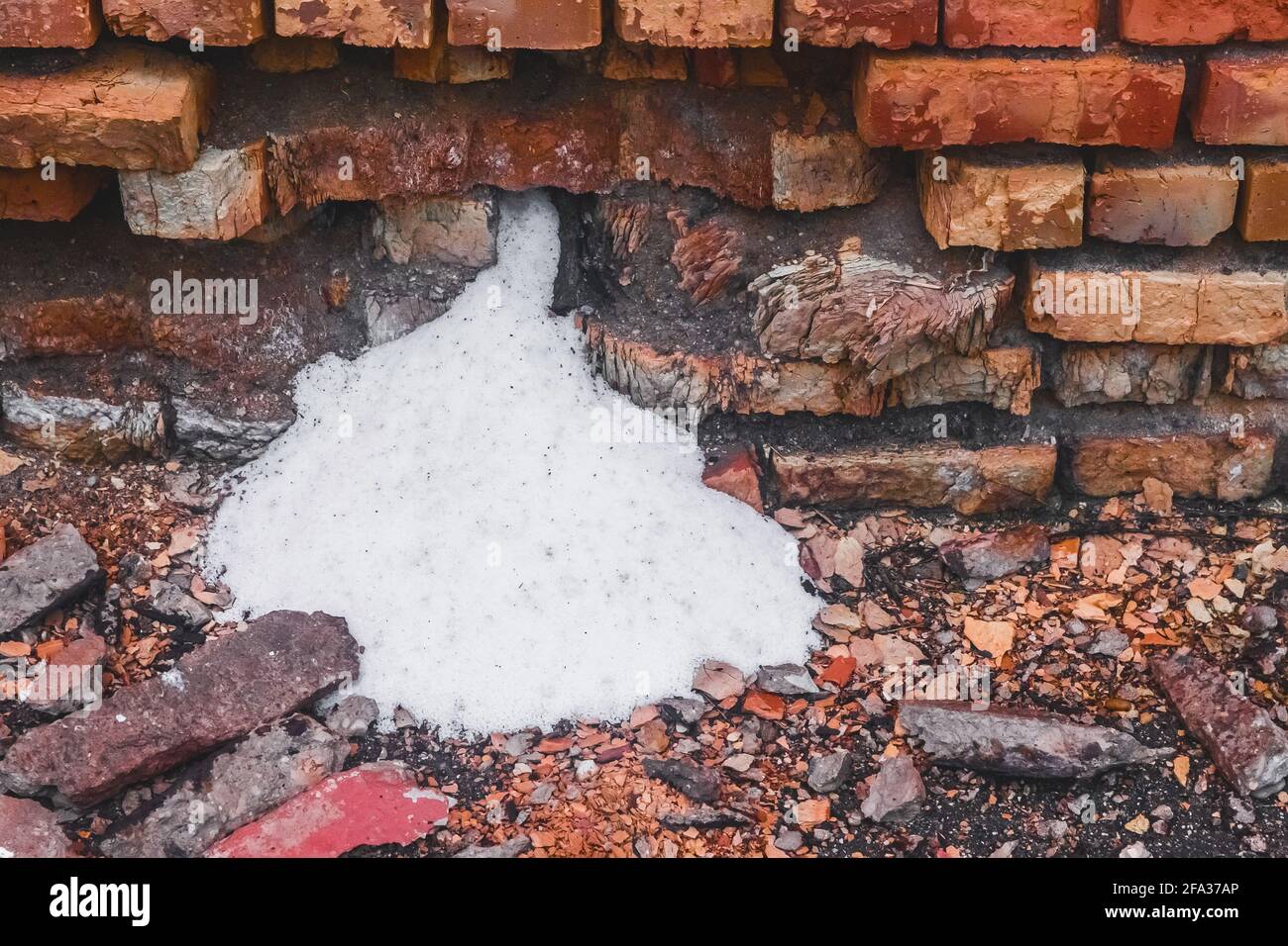 Saltpeter d'ammoniac blanc, l'engrais s'est réveillé par le vieux mur de briques détruit de l'entrepôt industriel avec de l'engrais. Banque D'Images