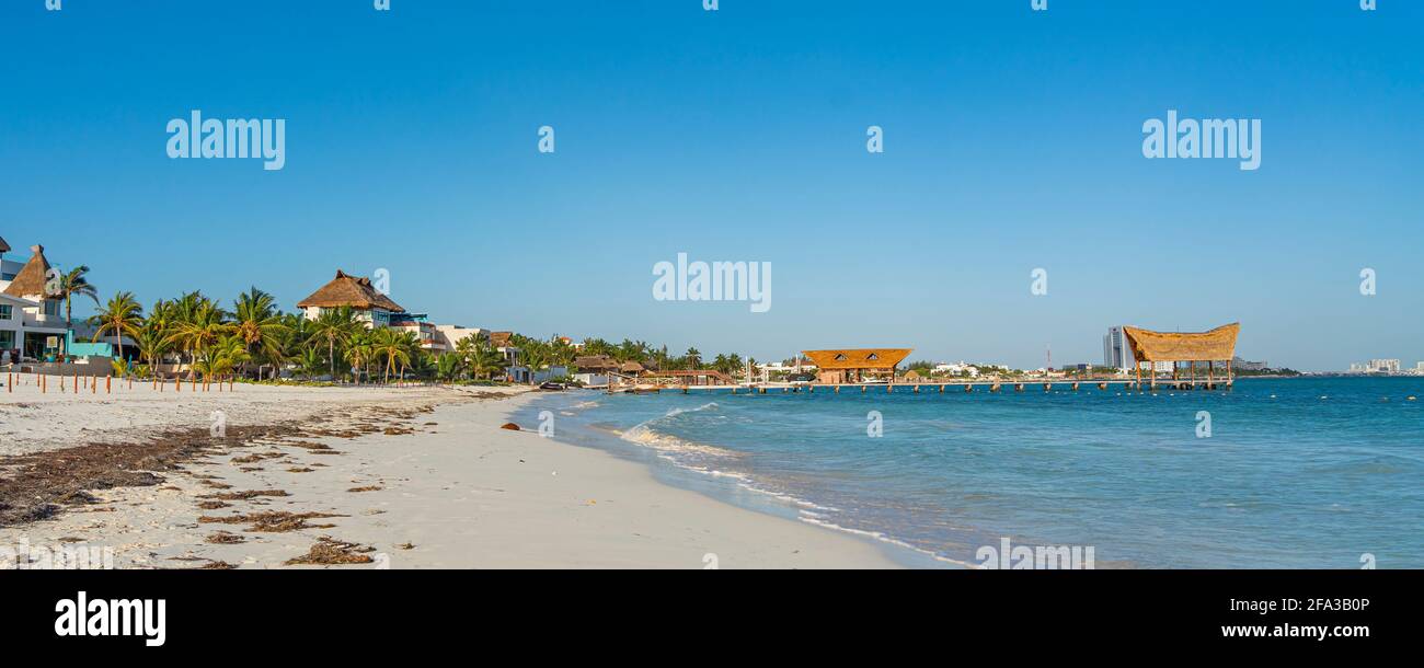 Matin à Ancha Beach à Cancun Mexique avec l'océan calme, fond bleu ciel, huttes à la jetée avec toit de chaume Banque D'Images