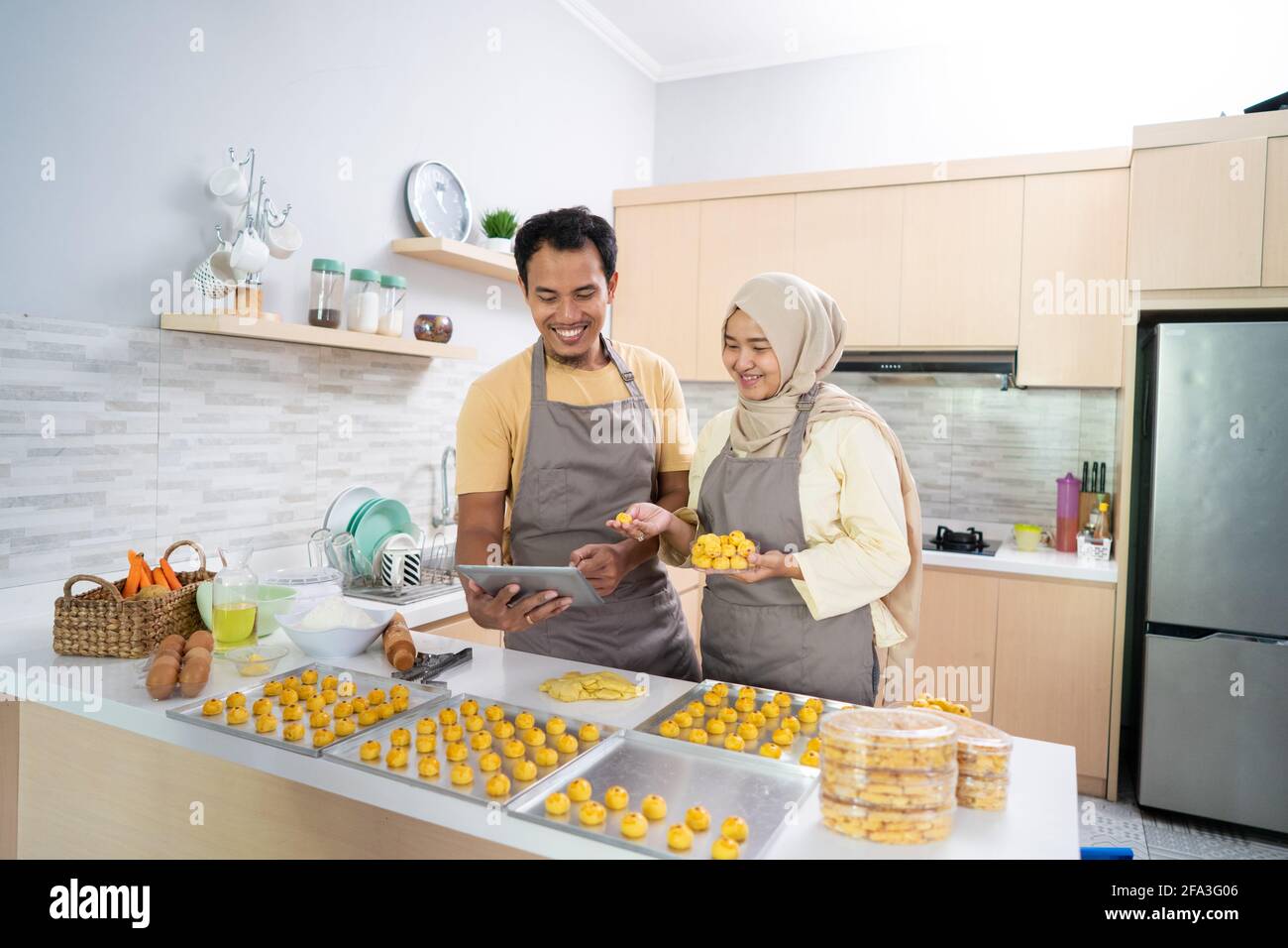 un couple musulman avec un pc de tablette qui fait cuire un gâteau à la vente pendant le ramadan Banque D'Images