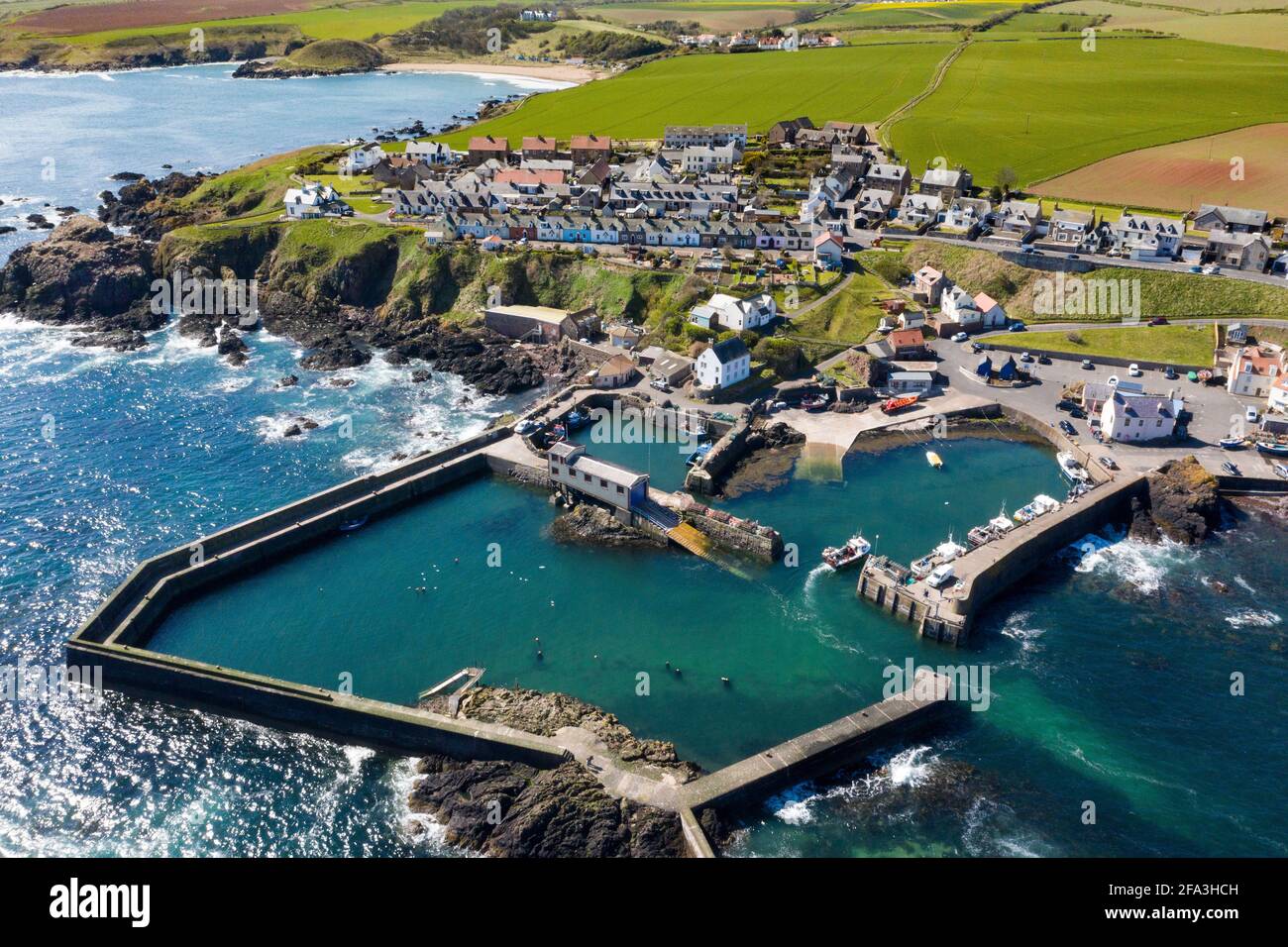 Vue aérienne montre un bateau de pêche qui retourne au port de St Abbs sur la côte du Berwickshire, Écosse, Royaume-Uni. Banque D'Images Vue aérienne montre un bateau de pêche qui retourne au port de St Abbs sur la côte du Berwickshire, Écosse, Royaume-Uni. Banque D'Images