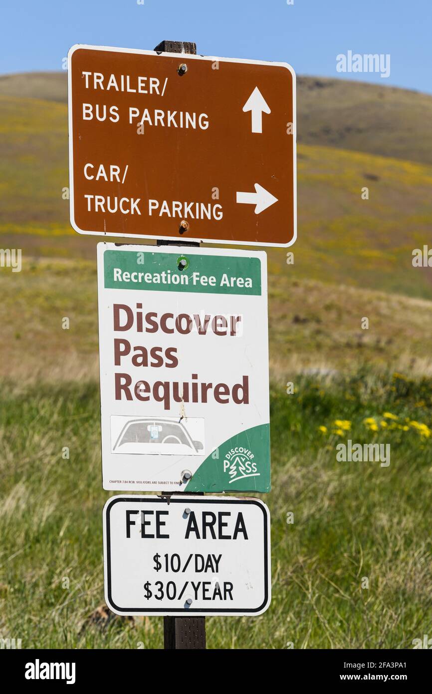 Trois panneaux d'information dans un parc de l'État de Washington avec des détails sur les frais, des informations sur les passes et des indications de stationnement sur un panneau Banque D'Images