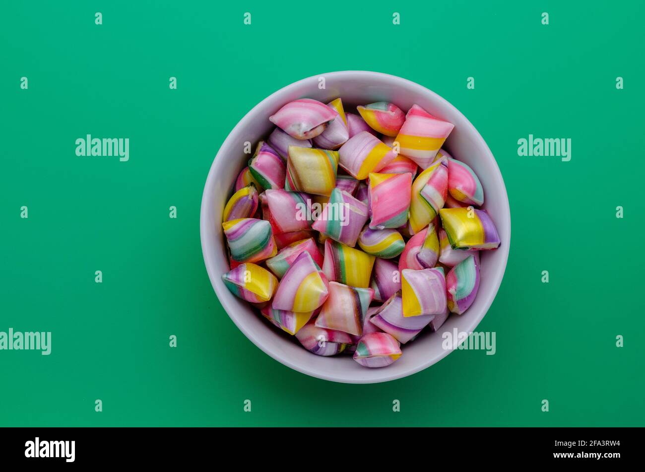 Tasse blanche pleine de bonbons durs colorés Banque D'Images