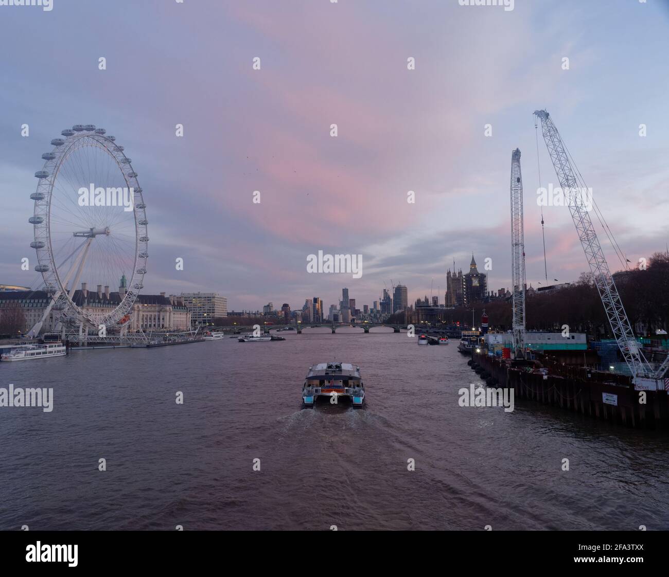 Londres, Grand Londres, Angleterre - 17 2021 avril : bateau sur la Tamise à l'approche du coucher du soleil avec le London Eye sur la gauche et le pont de Westminster. Banque D'Images