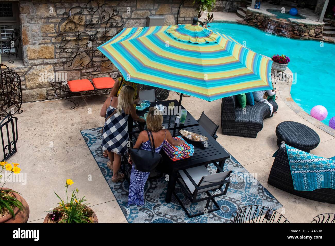 Tulsa OK USA 5 20 2018 femmes debout autour du patio table à côté de la piscine avec de beaux meubles de plein air - top vue Banque D'Images