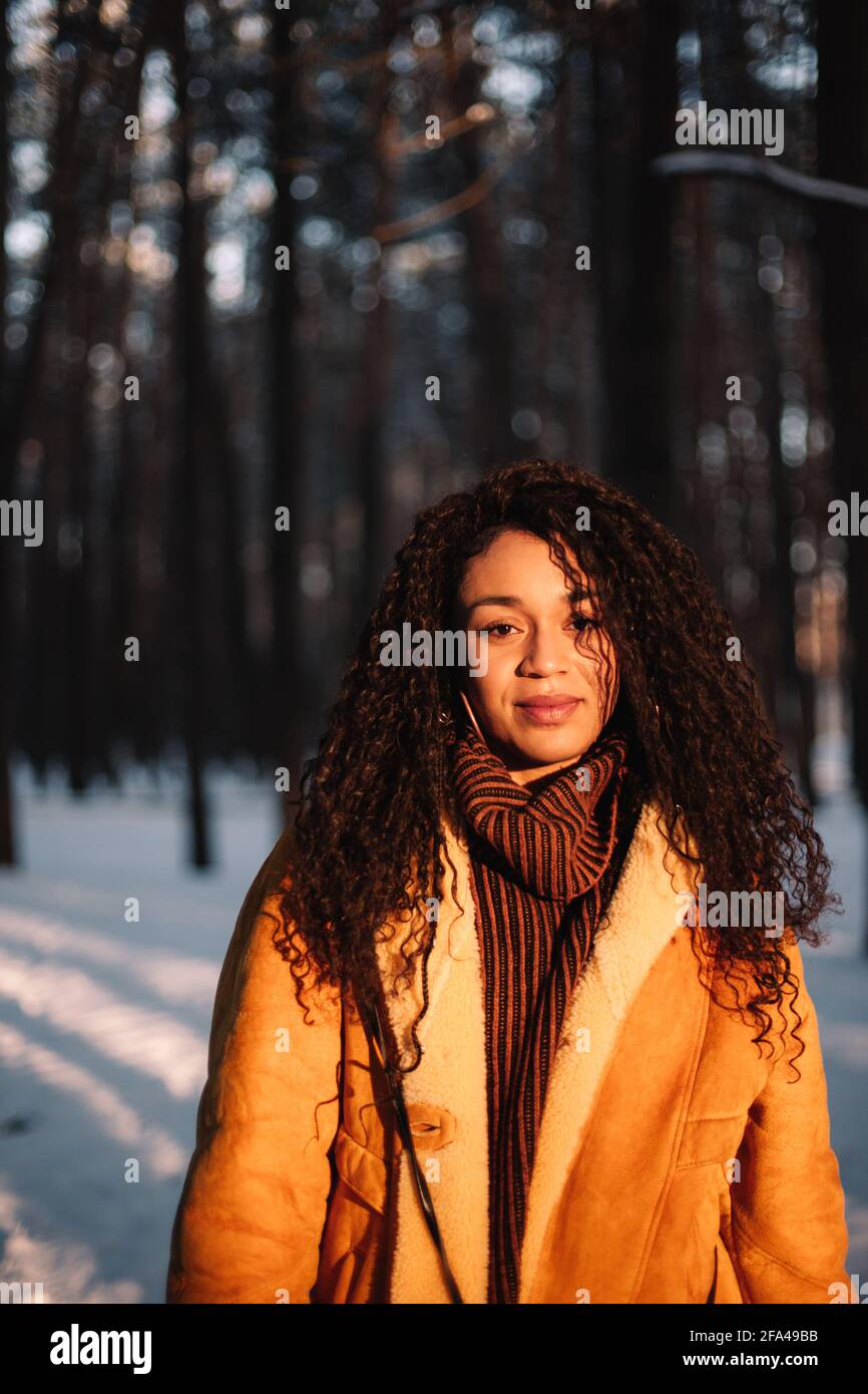 Portrait de la jeune femme debout dans le parc en hiver pendant jour ensoleillé Banque D'Images