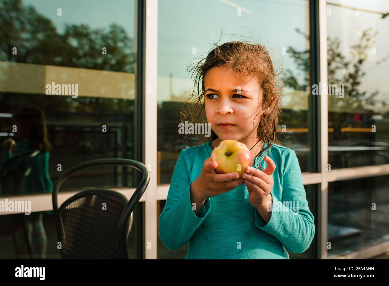 Jeune fille sur le patio du restaurant manger. Une pomme Banque D'Images