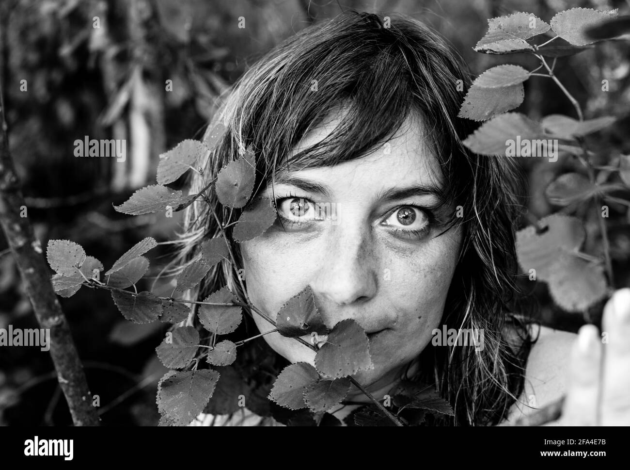 Portrait d'une femme aux yeux expressifs dans le parc. Photo en noir et blanc. Banque D'Images Portrait d'une femme aux yeux expressifs dans le parc. Photo en noir et blanc. Banque D'Images