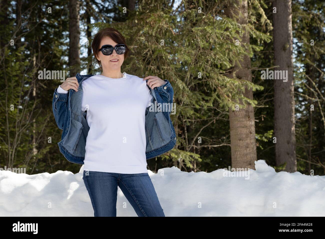 Sweat-shirt en polaire blanc à encolure ras du cou avec une femme portant une veste en denim. Modèle de sweat-shirt poids lourd, maquette Banque D'Images