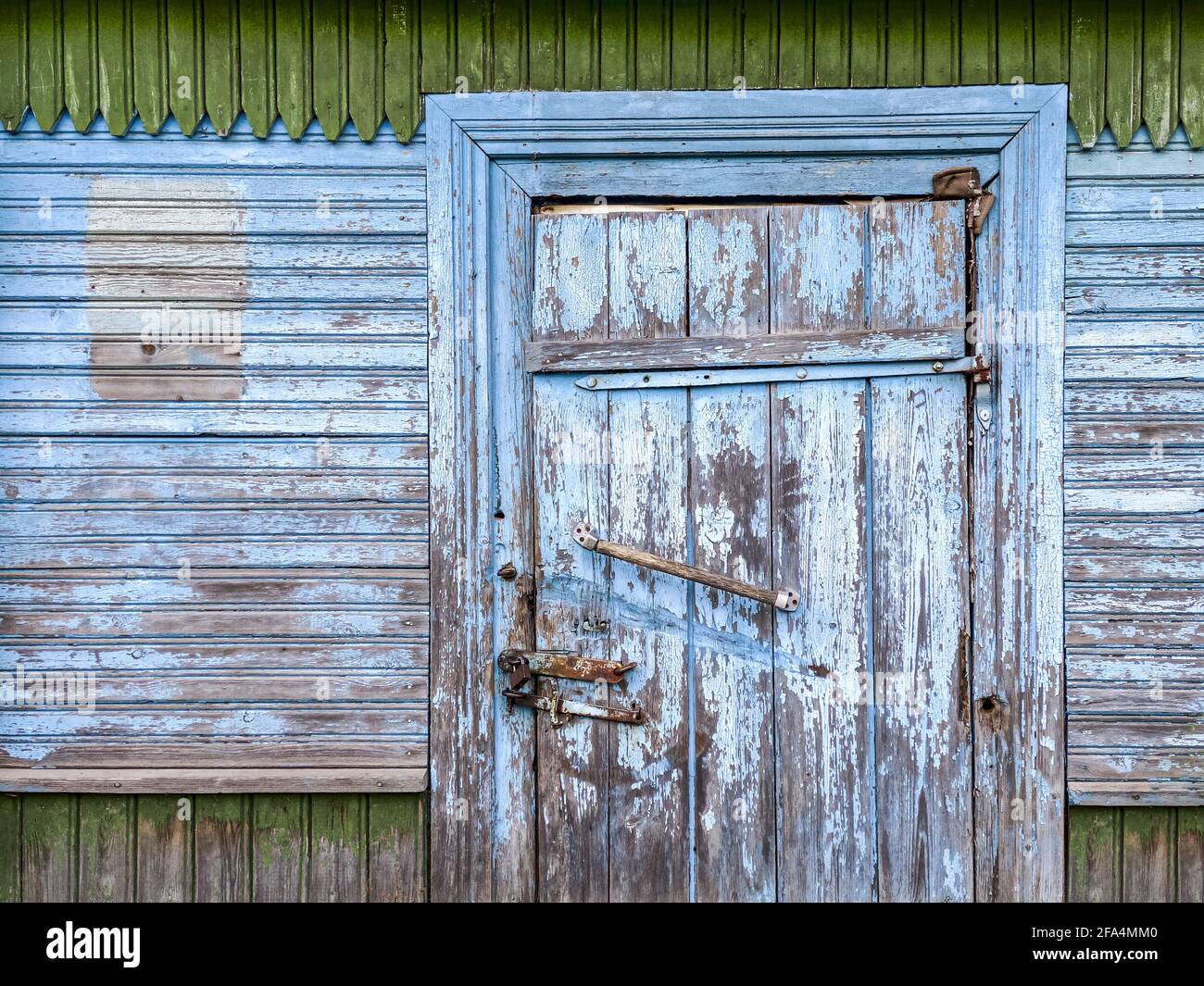 porte fermée avec cadenas sur une grange en bois aux intempéries peinte en bleu mur Banque D'Images