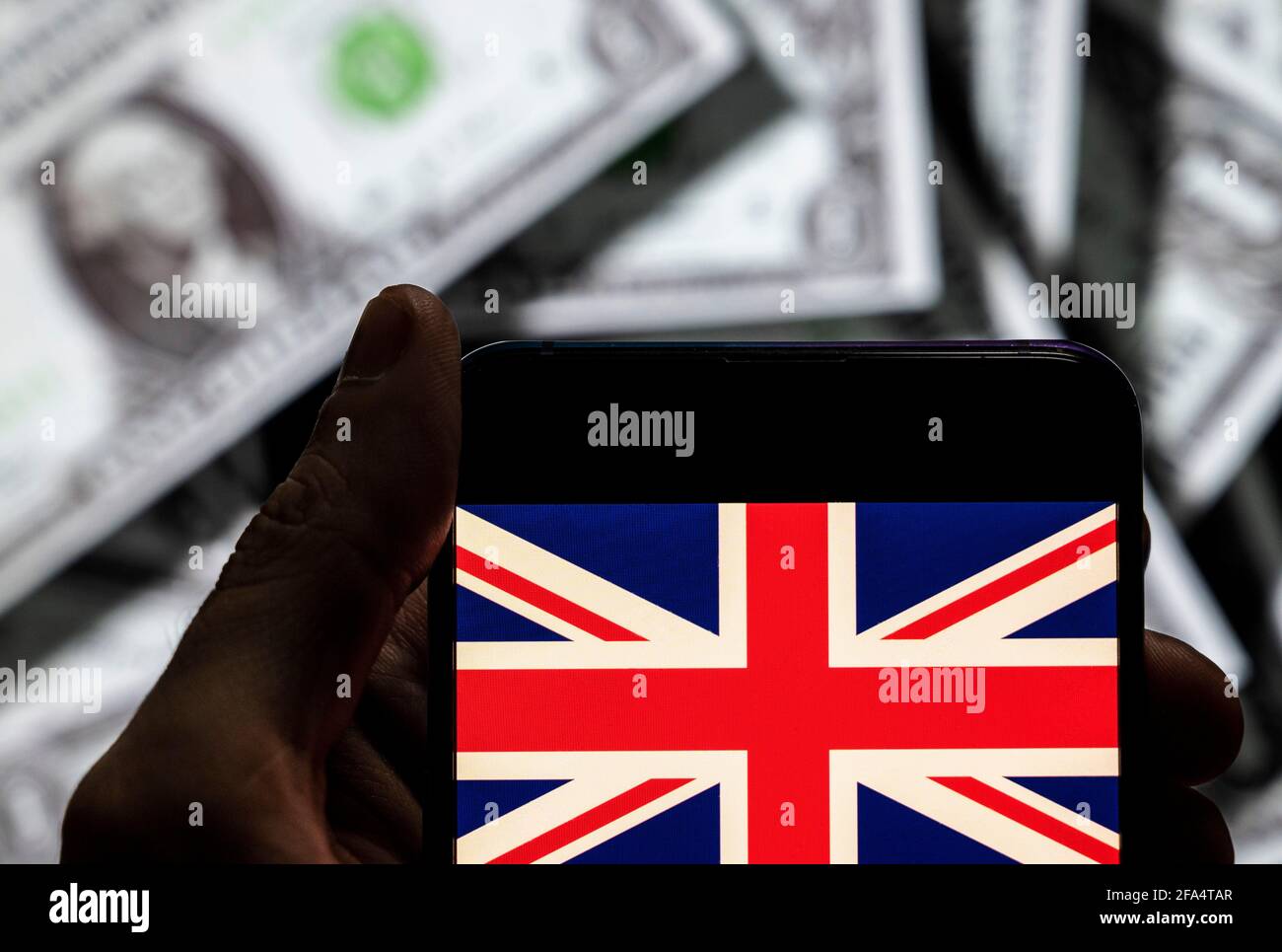 Dans cette illustration de photo le drapeau du Royaume-Uni de Grande-Bretagne et d'Irlande du Nord vu sur un écran d'appareil mobile Android avec la devise de l'icône dollar des États-Unis, symbole d'icône $ en arrière-plan. Banque D'Images