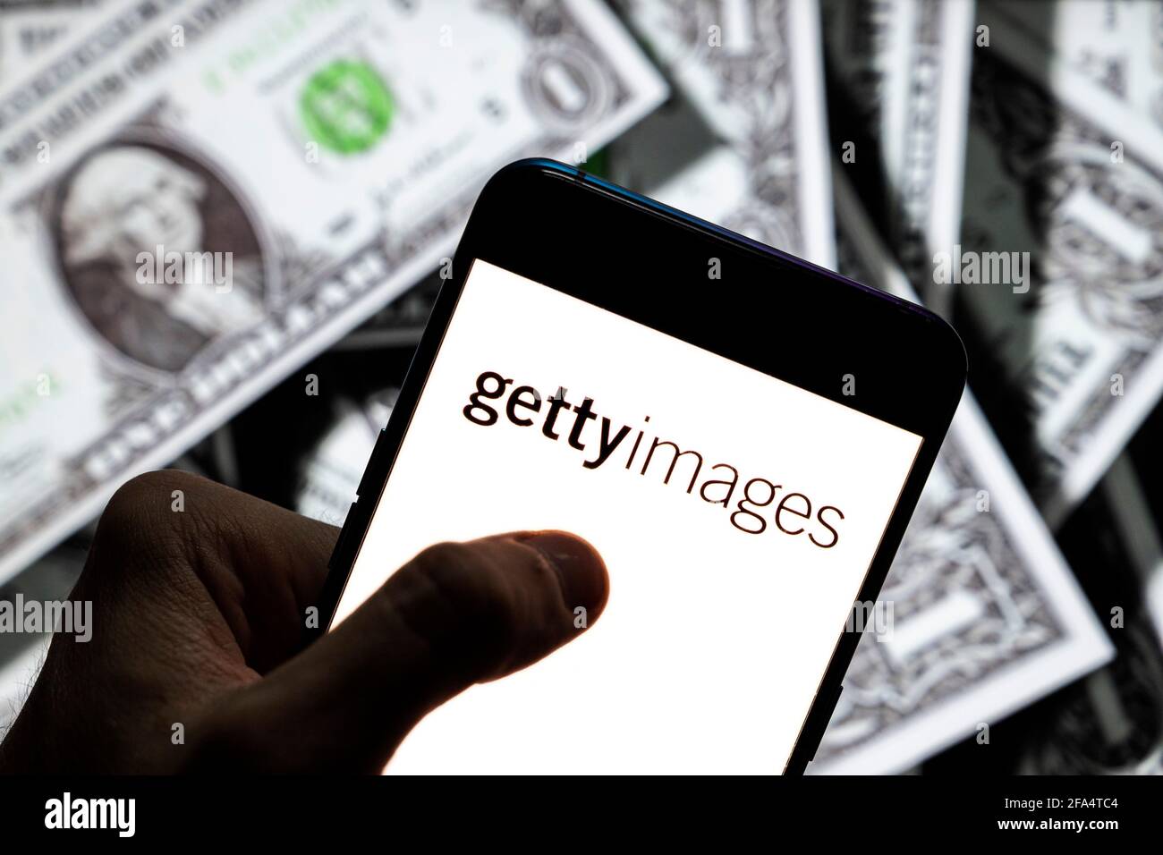 Dans cette illustration photo, les photos visuelles britanniques-américaines et les images éditoriales de la société Getty Images logo vu sur un écran d'appareil mobile Android avec la devise de l'icône dollar des Etats-Unis, symbole de l'icône $ en arrière-plan. Banque D'Images