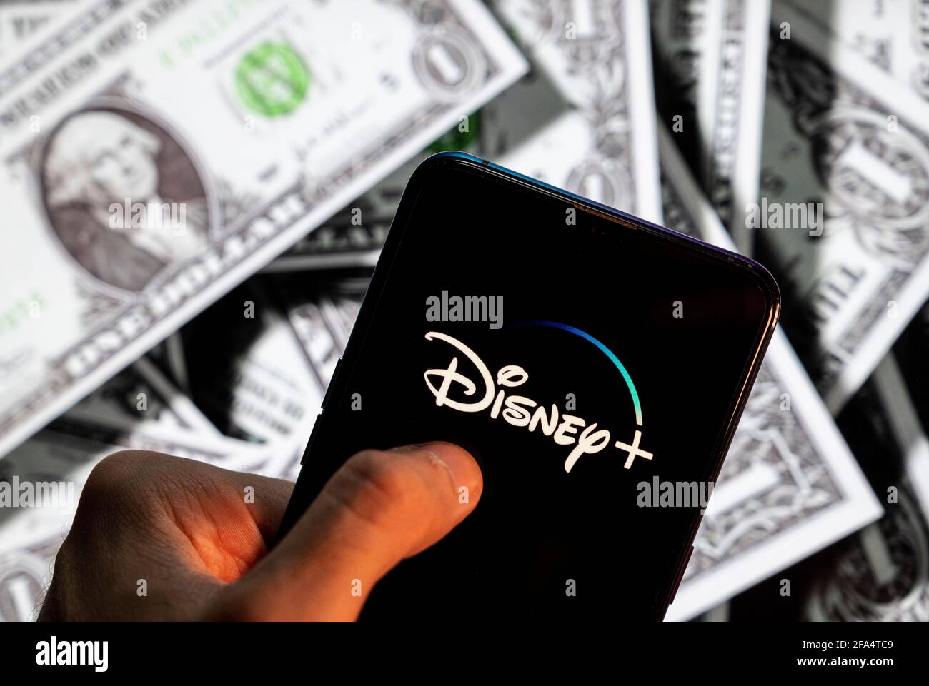 Dans cette photo illustration, la plate-forme de service d'abonnement en streaming vidéo en ligne appartenant à Disney, Disney+ (plus), logo vu sur un écran d'appareil mobile Android avec la devise de l'icône dollar des États-Unis, symbole d'icône $ en arrière-plan. Banque D'Images