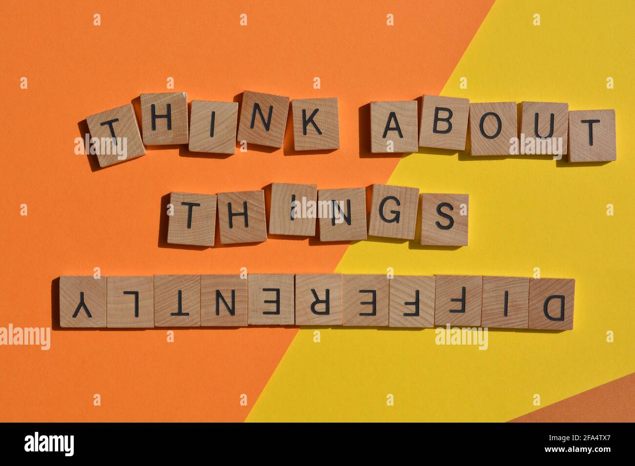 Pensez aux choses différemment, les mots dans des lettres de l'alphabet en bois isolées sur fond coloré Banque D'Images