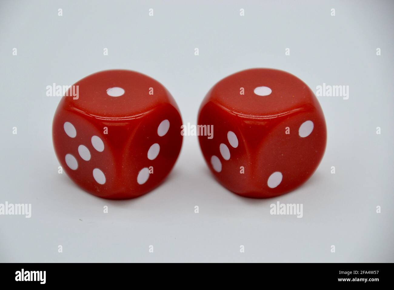 Paire de dés rouges de casino montrant un double oeil de serpent dans un studio isolé tourné sur fond blanc Banque D'Images