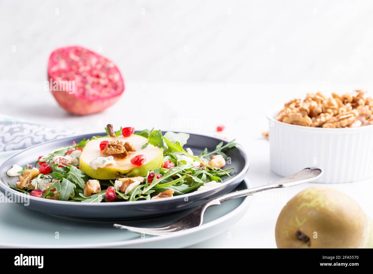 Salade fraîche et saine avec arugula, fromage gorgonzola, grenade et poires. Banque D'Images