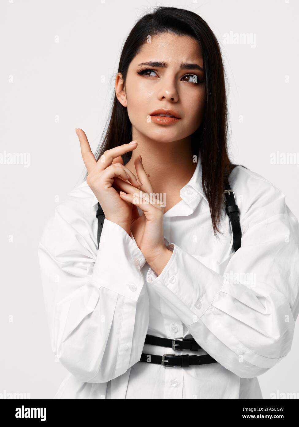 femme en chemise blanche avec bretelles noires tient les mains près vue  rognée de la face Photo Stock - Alamy