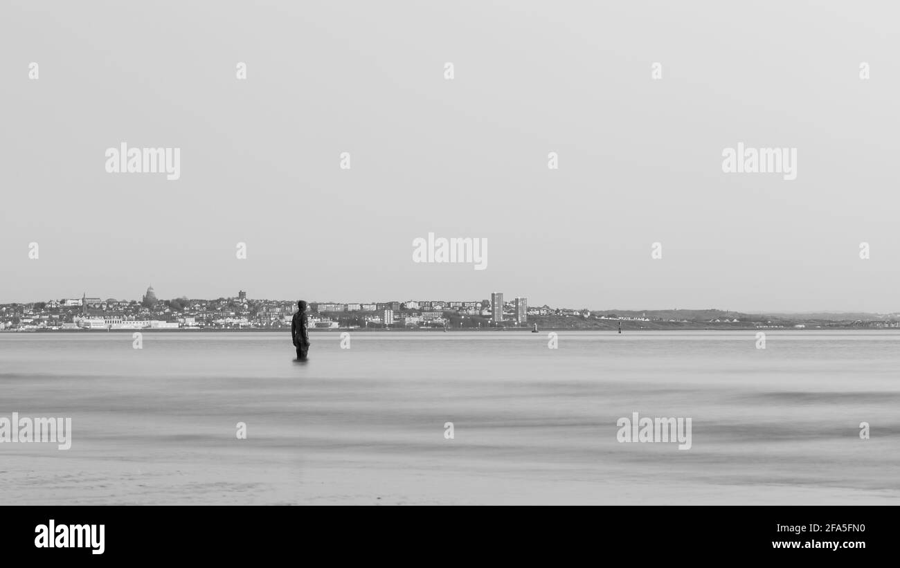 Un homme de fer en noir et blanc vu en face de la péninsule Wirral. C'est une partie d'un autre endroit, l'installation artistique sur la plage de Crosby près de Liverp Banque D'Images