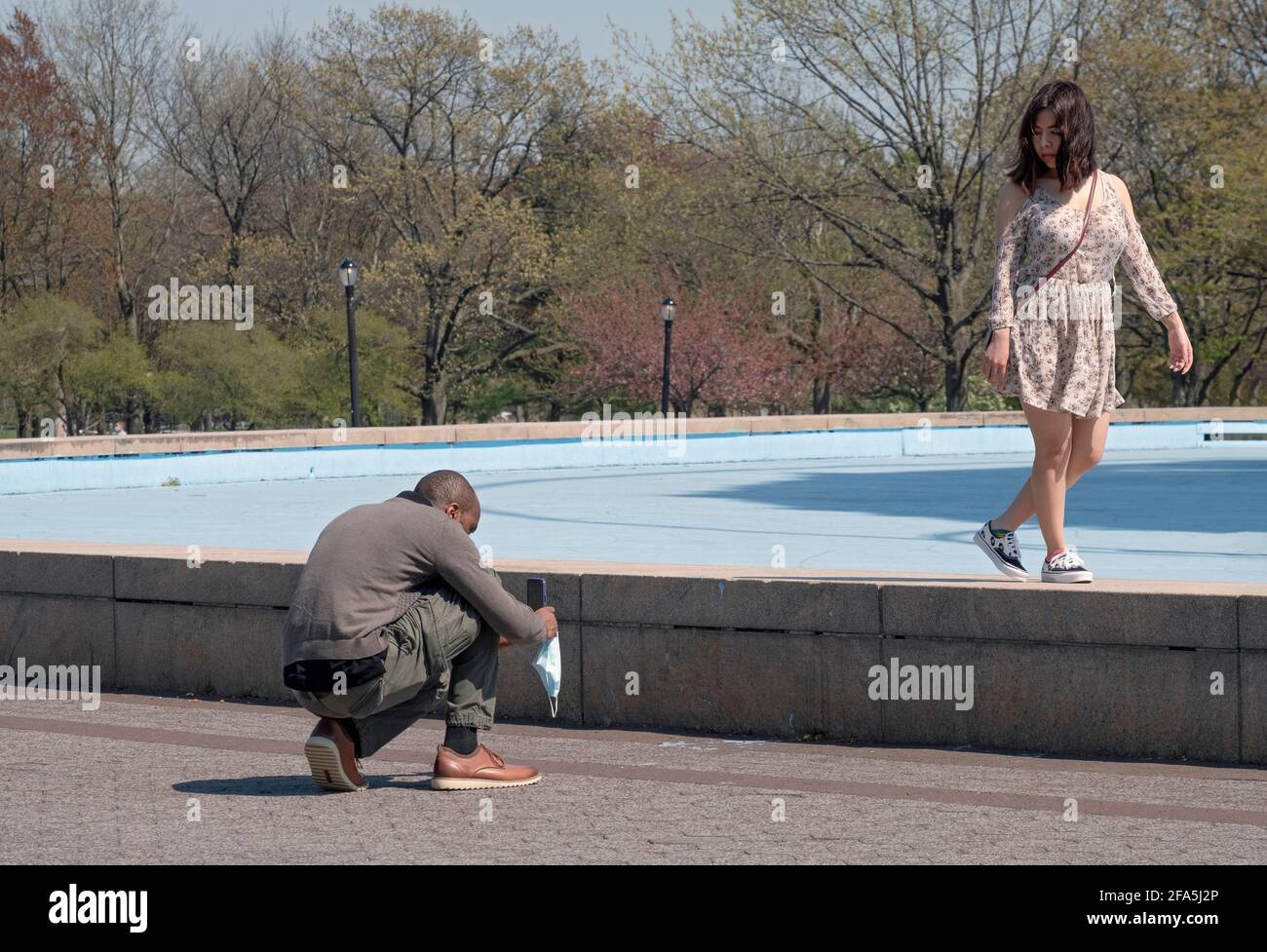 Lors d'une semaine calme au printemps, un couple prend des photos de téléphone portable près de Unisphere sur Flushing Meadows Corona Park dans Queens New York City. Banque D'Images