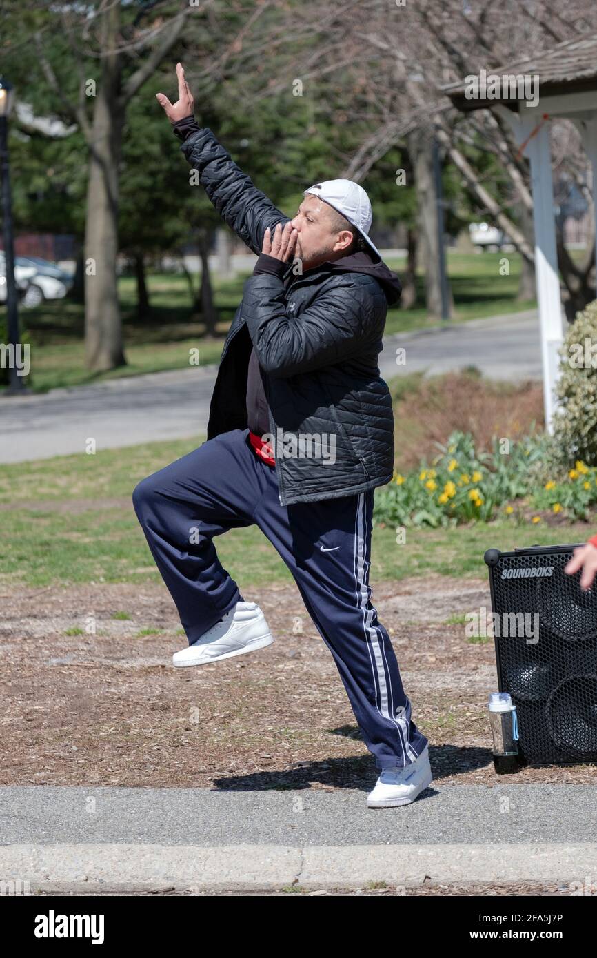 Un homme mène un cours de Zumba par un entraînement énergique d'exercice de danse dans un parc de Queens, New York. Banque D'Images