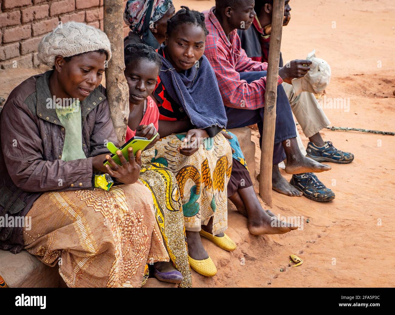 Femme dans un village isolé au Malawi utilisant un smartphone Banque D'Images