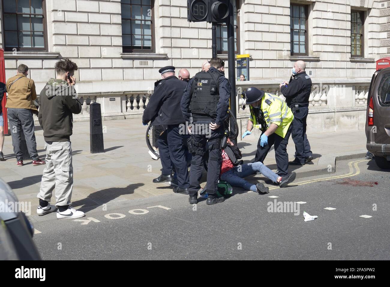 Londres, Angleterre, Royaume-Uni. Police métropolitaine assistant à une collision entre une voiture et un cycliste au coin de Whitehall et de la place du Parlement Banque D'Images