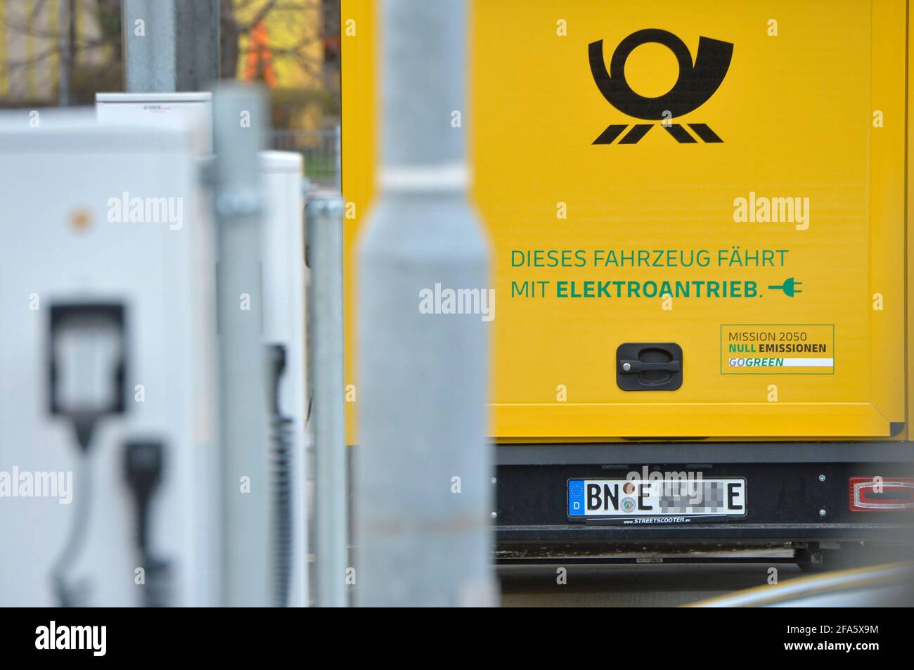 01 avril 2021, Saxe, Leipzig: "Ce véhicule fonctionne à l'électricité". Plusieurs des transporteurs électriques StreetScooter de Deutsche Post se trouvent dans des stations de charge sur un site DHL à Leipzig. Photo: Volkmar Heinz/dpa-Zentralbild/ZB Banque D'Images