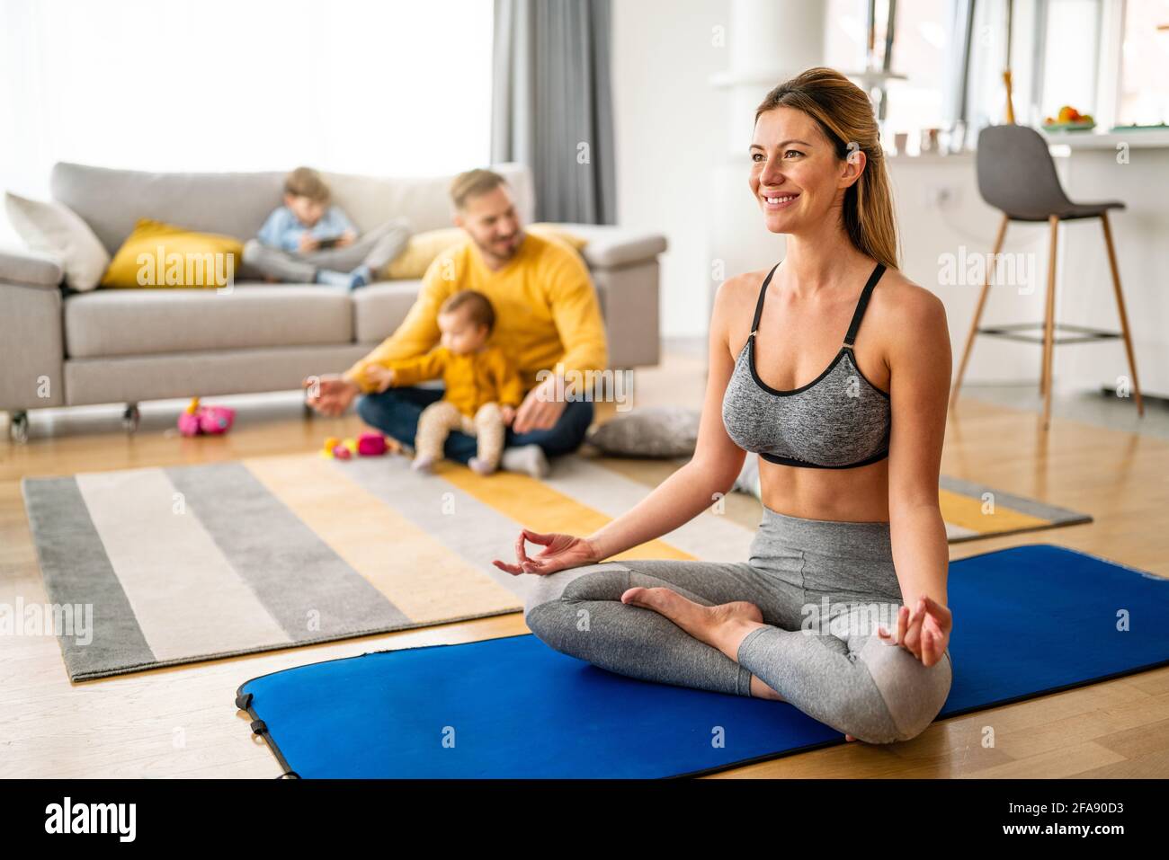 La jeune femme fait de l'exercice de yoga à la maison. Forme physique, entraînement, vie saine et concept de régime. Banque D'Images