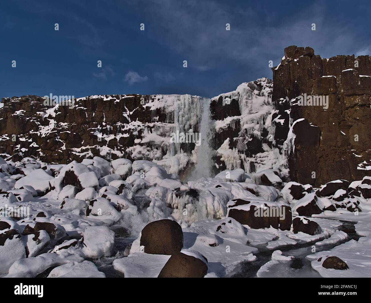 Belle vue de face de la cascade d'Öxarárfoss dans le canyon rocheux d'Almannagjá dans le parc national de Þingvellir, cercle d'or, Islande, en hiver. Banque D'Images