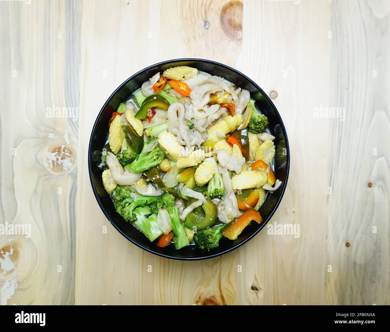 Caille de légumes, jeune maïs avec champignons et poivrons avec un fond en bois Banque D'Images