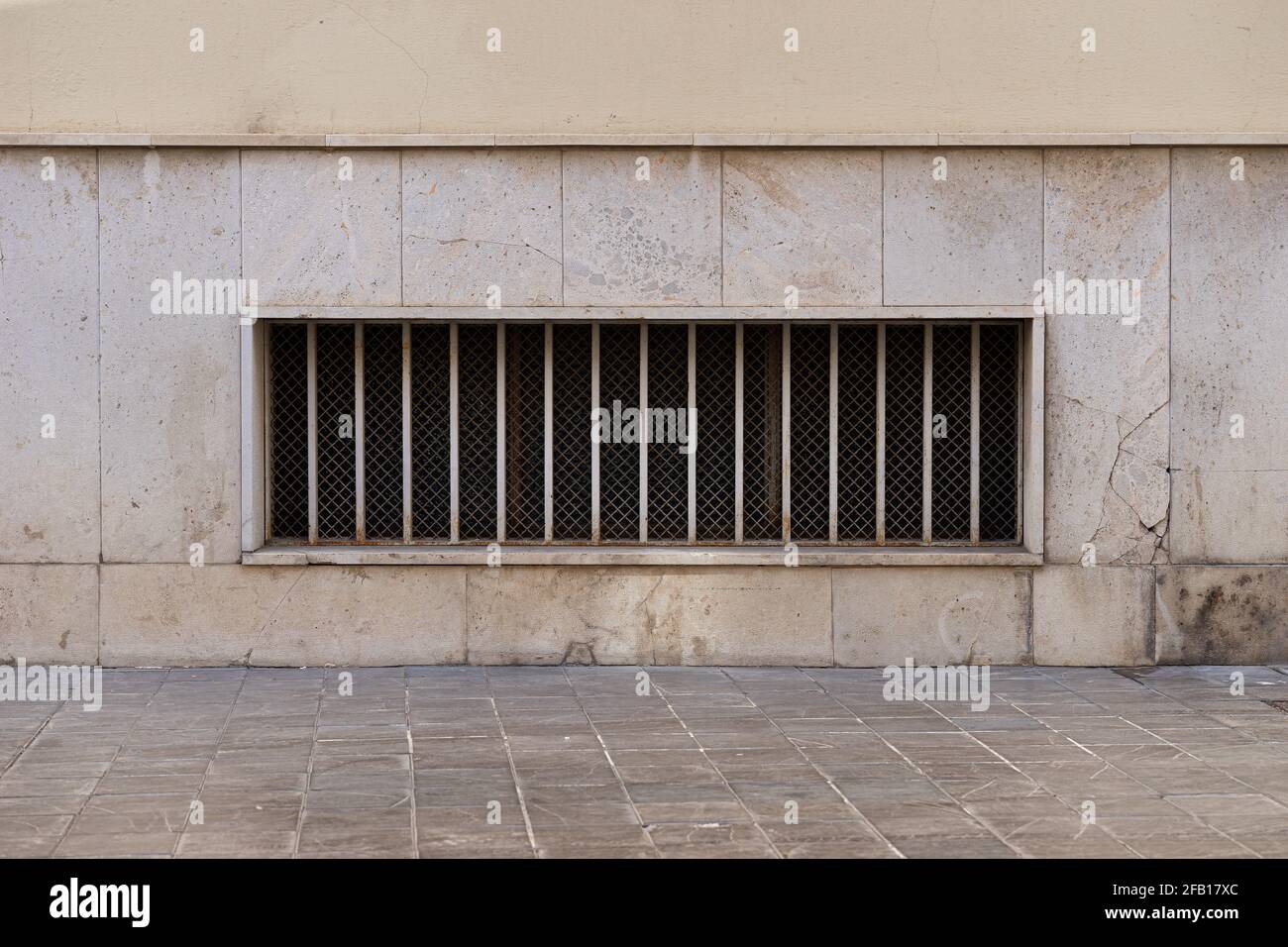 Fenêtre moderne avec grille en fer sur un mur en pierre. Valence, Espagne Banque D'Images