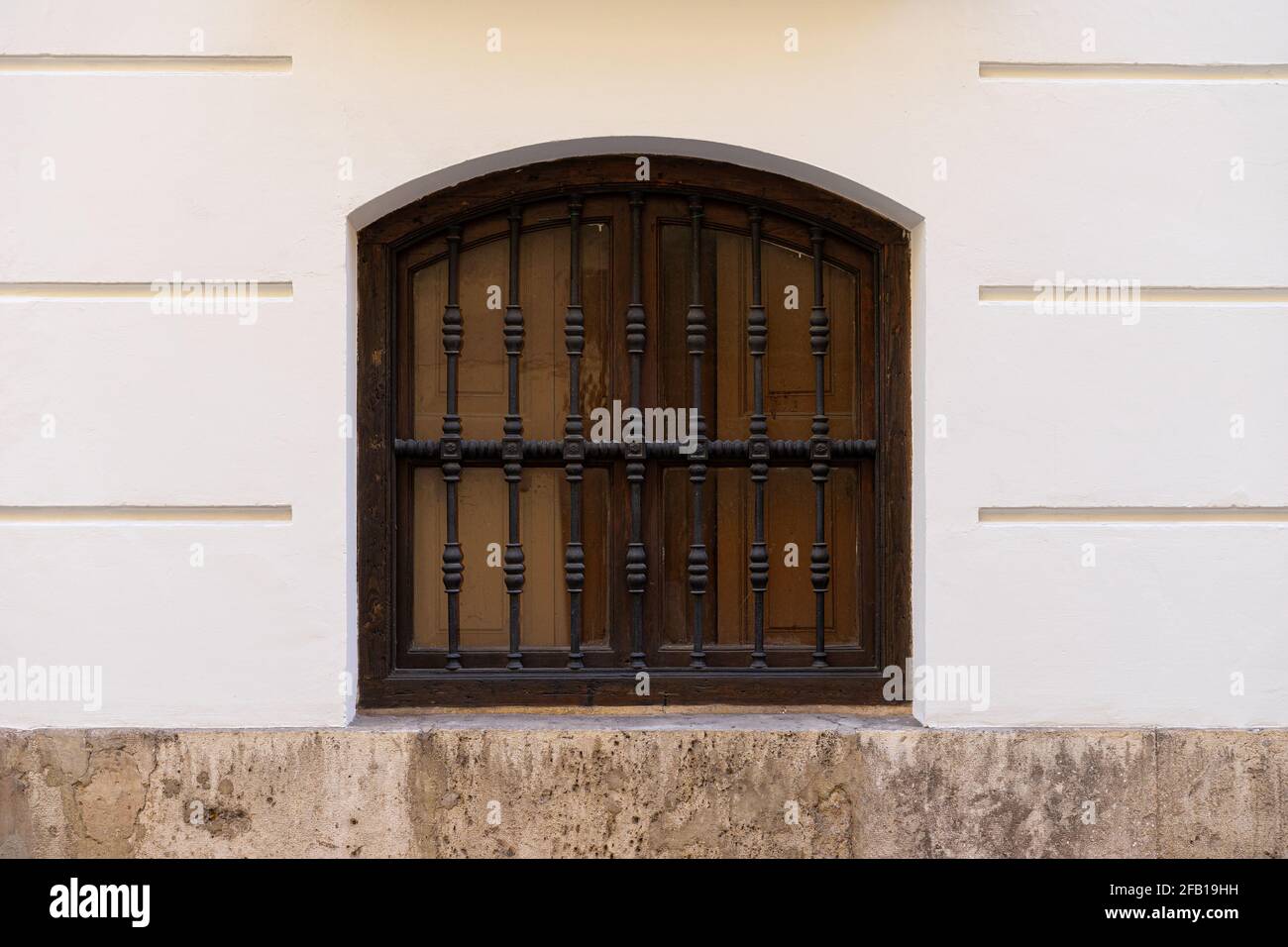 Fenêtre vintage avec grille en fer sur un mur en pierre. Valence, Espagne Banque D'Images