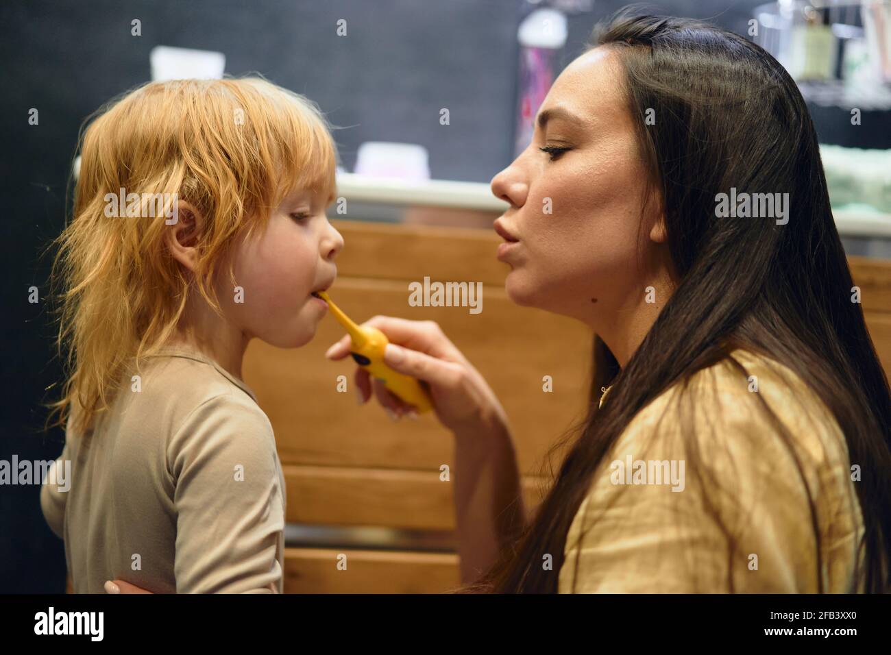 maman apprend à son fils à se brosser les dents. Dans la salle de bains. Banque D'Images